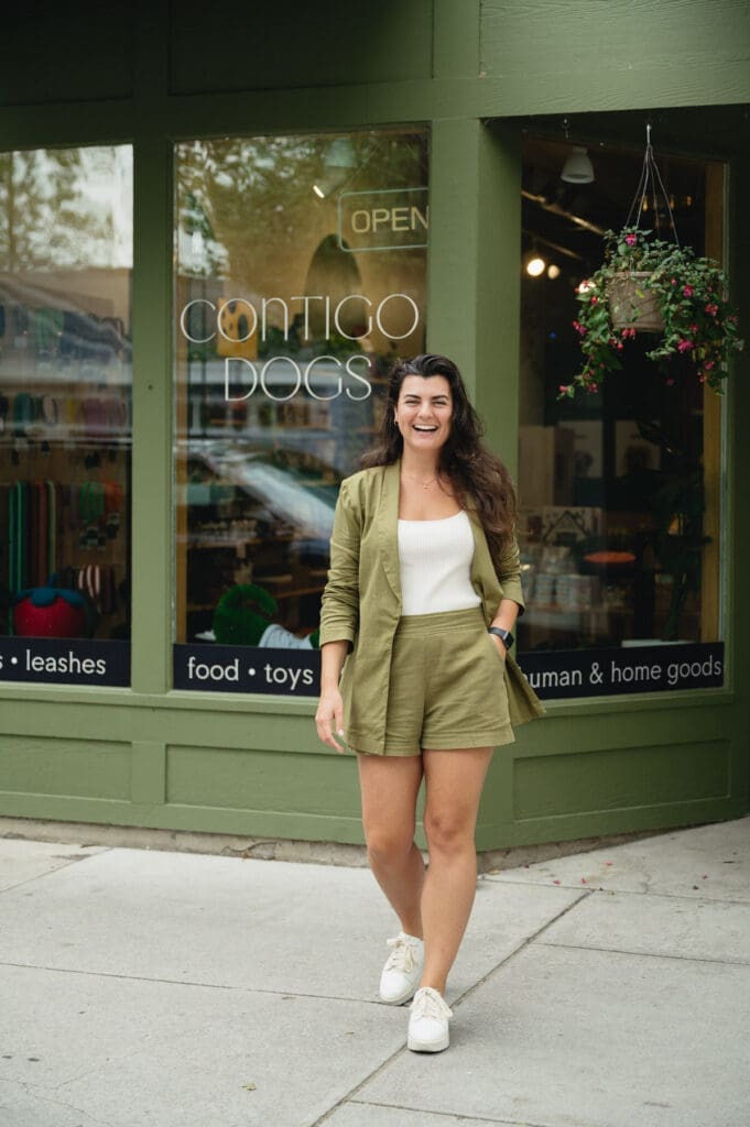 woman standing outside of Contigo Dogs pet store in Traverse City, Michigan